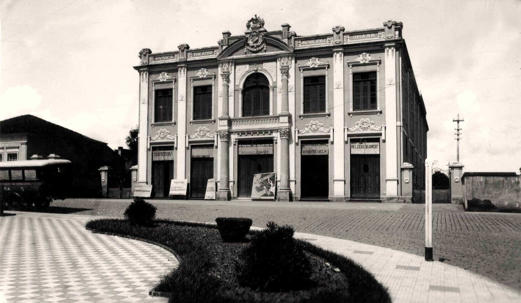 A fachada do Theatro em registro amplo, diante da praça do centro.
