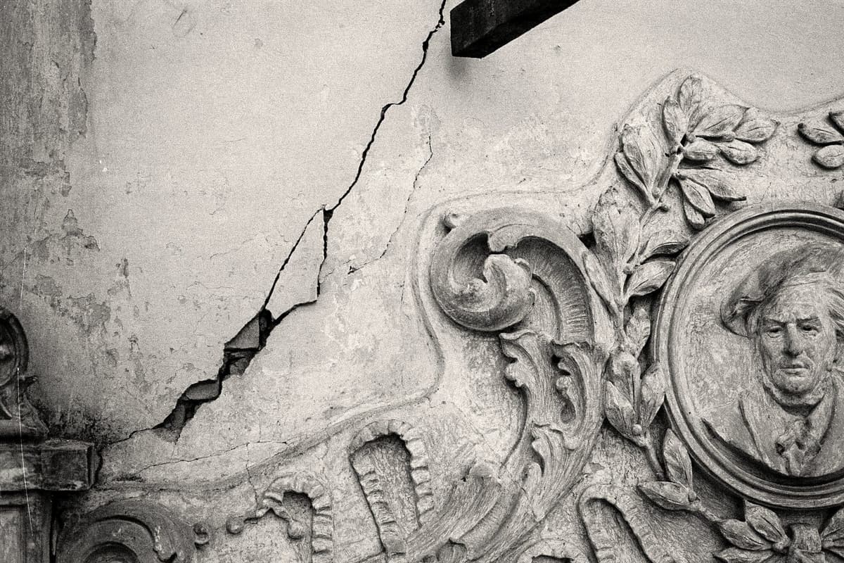 Uma rachadura aberta acima de uma porta — o estado de deterioração do edifício antes do restauro.