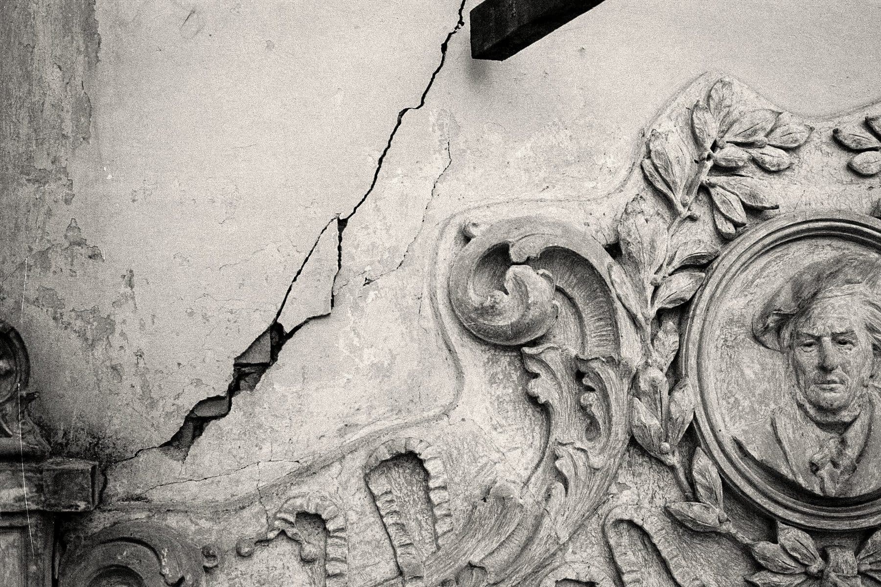 Uma rachadura aberta acima de uma porta — o estado de deterioração do edifício antes do restauro.