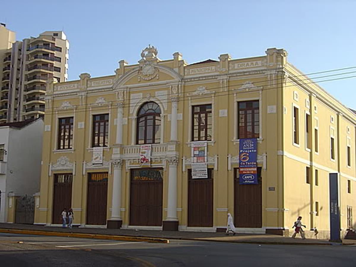 A fachada e a lateral do Theatro, em dia claro.