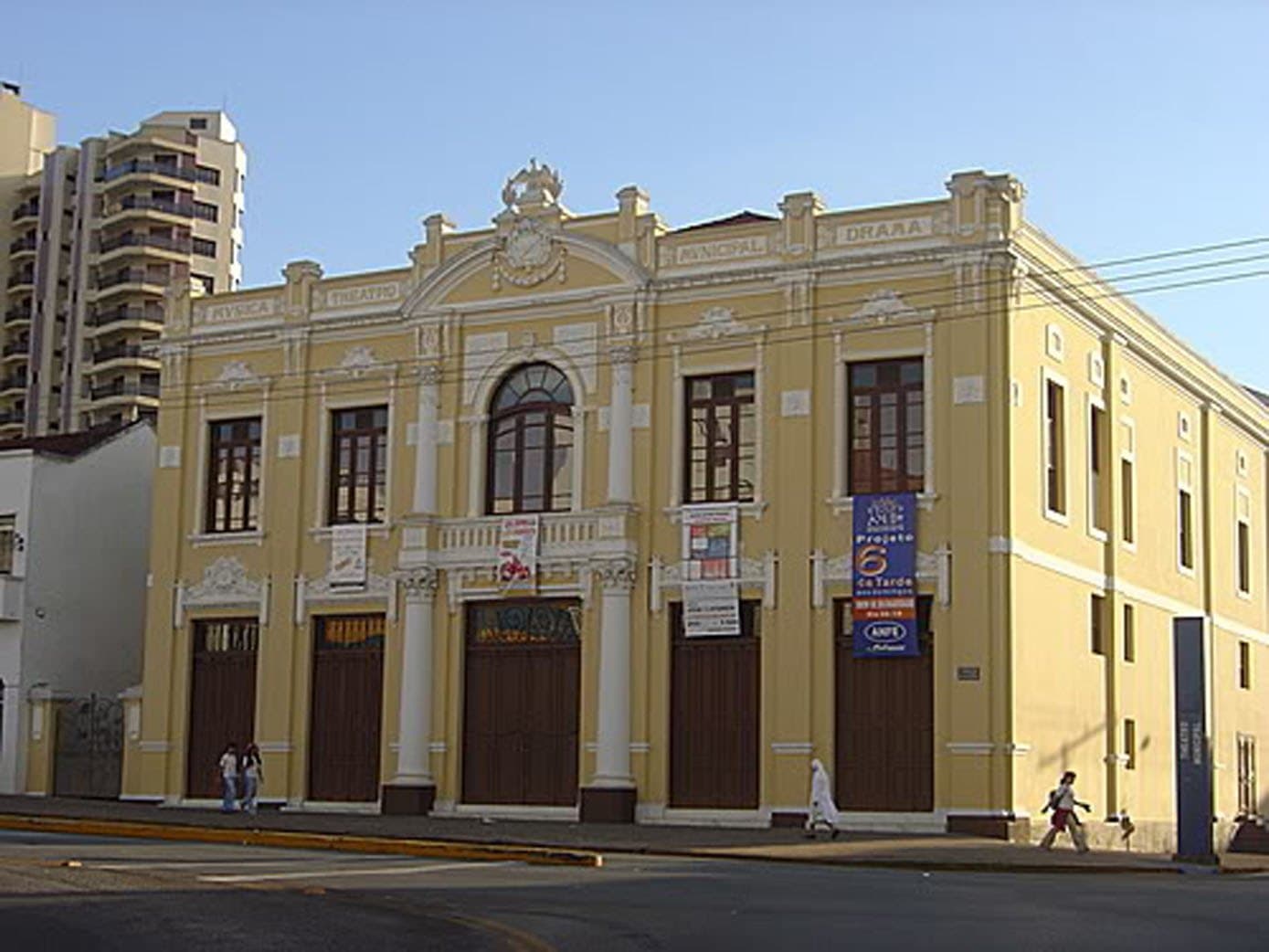 A fachada e a lateral do Theatro, em dia claro.