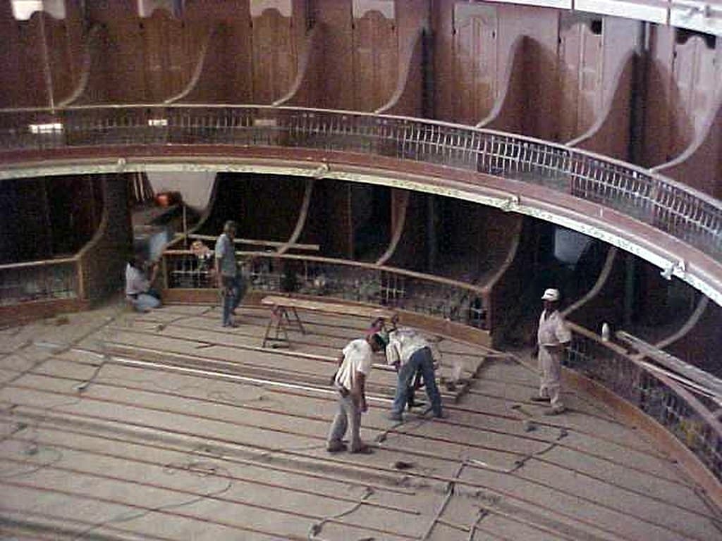 Operários montam a estrutura do piso da plateia, sob a curva das galerias.