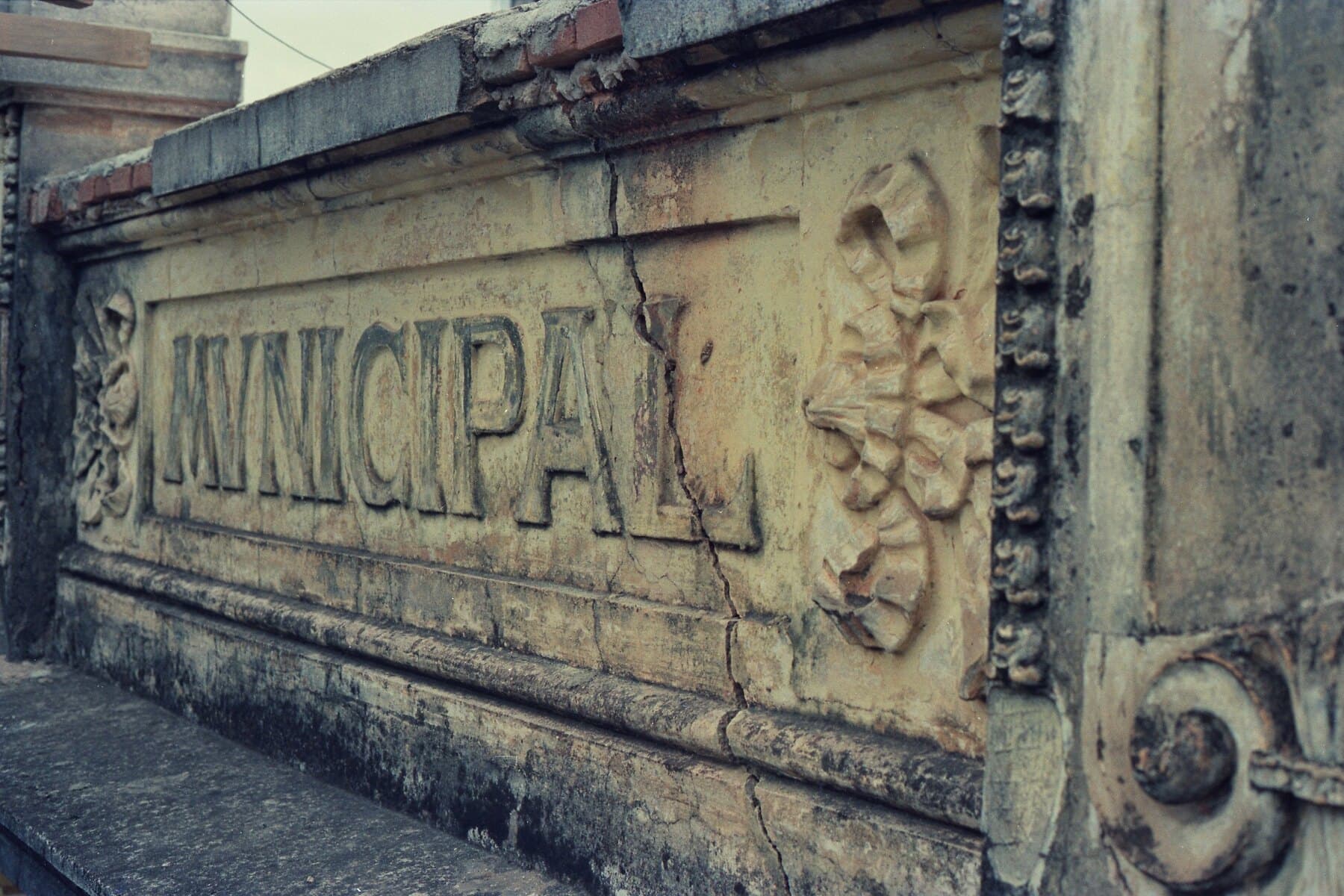 A inscrição “Municipal” na cornija da fachada — parte do programa decorativo eclético do edifício.