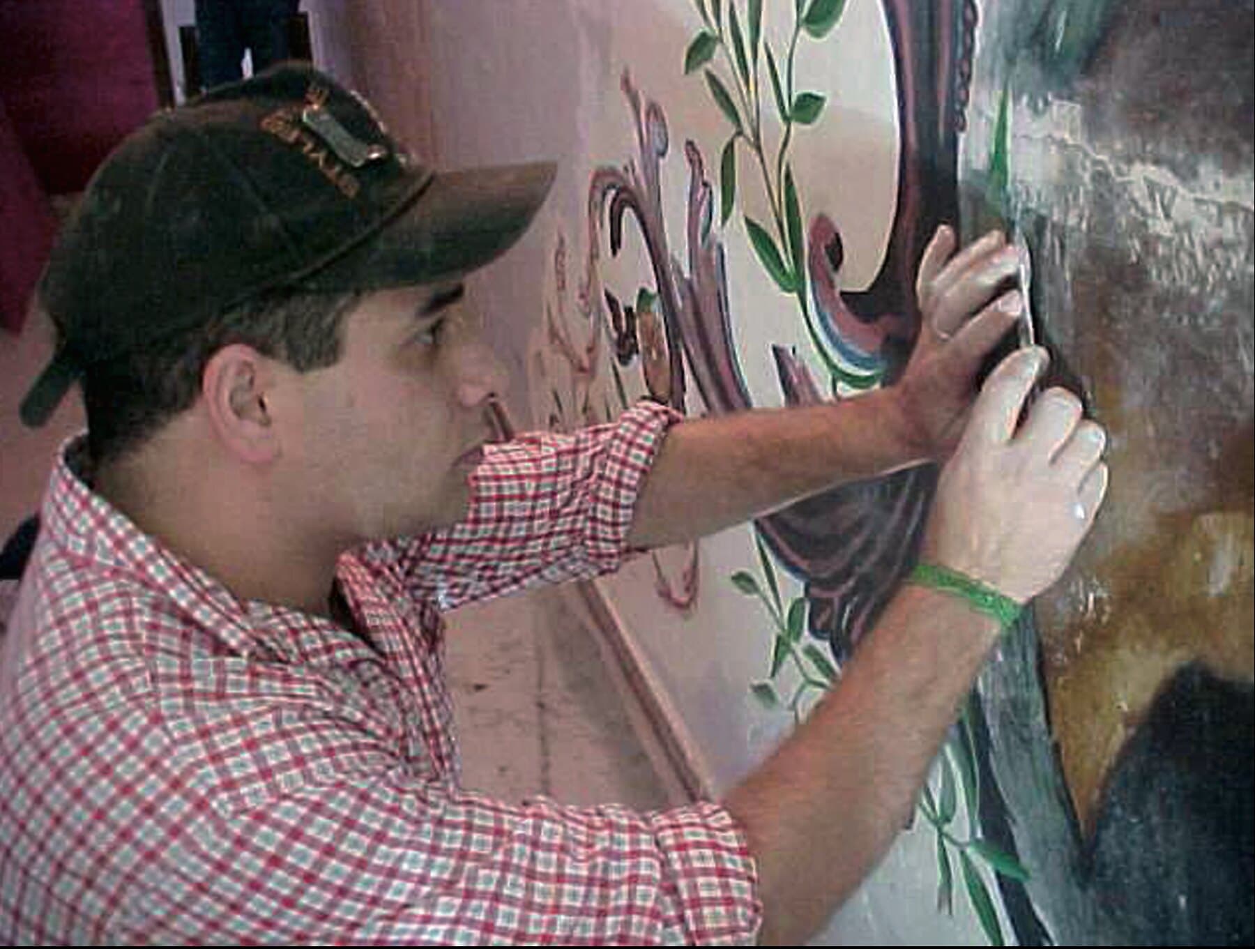 O restaurador Elias na recuperação da pintura ornamental da sala, durante as obras.