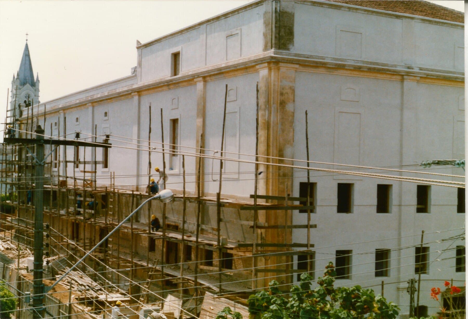 A fachada em recuperação, com o revestimento externo e a estrutura de andaimes.