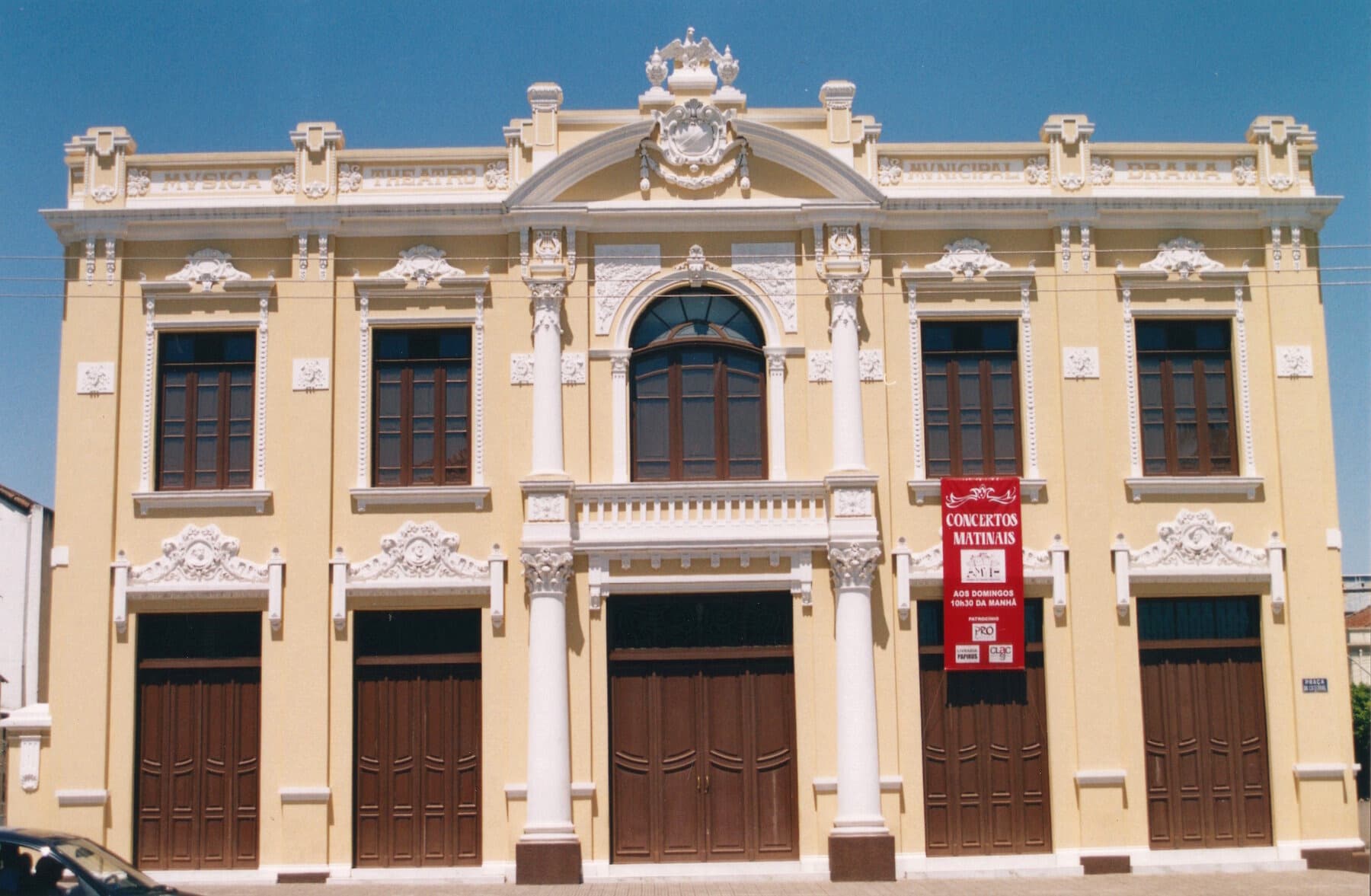 A fachada eclética recuperada, diante da praça.
