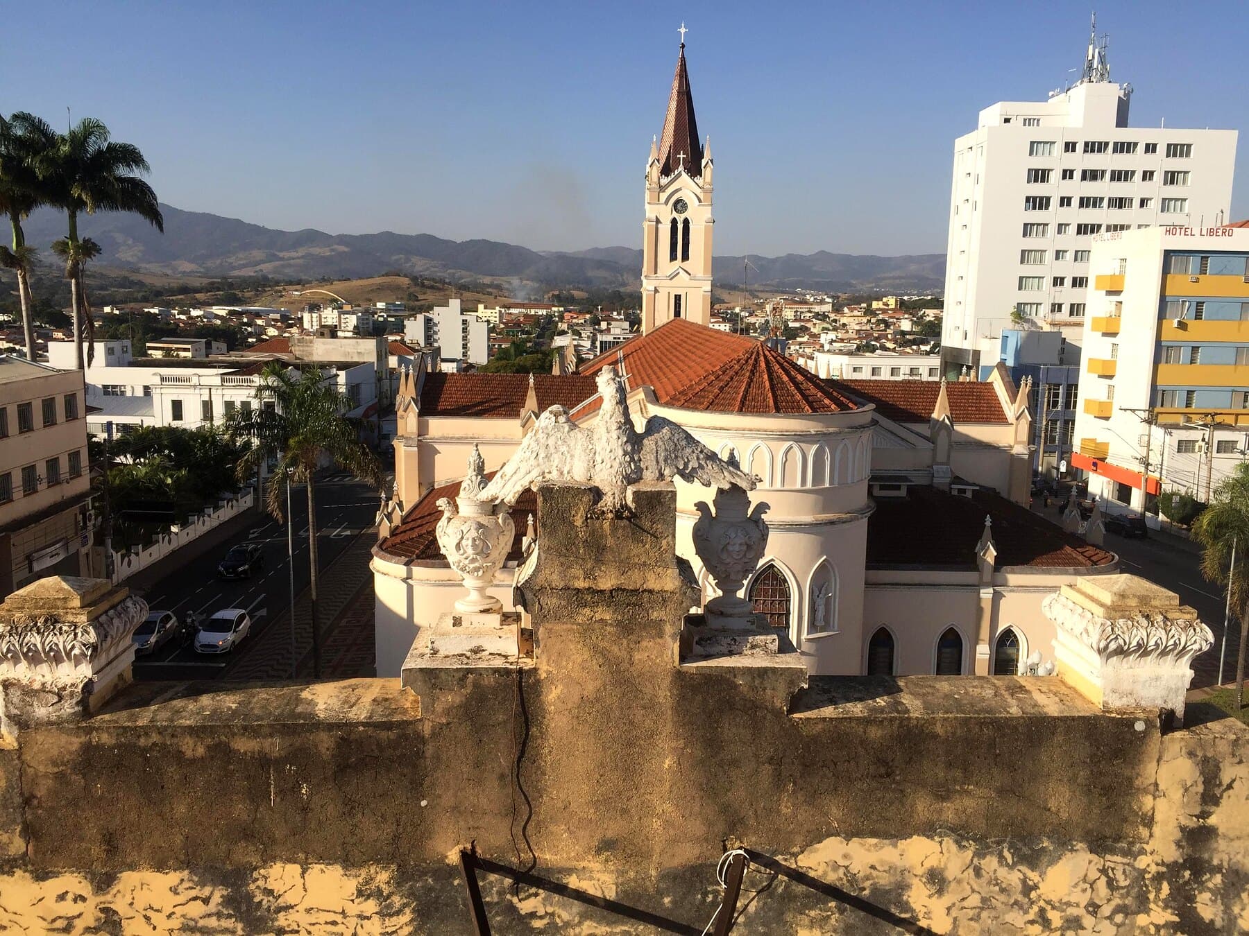 A cobertura em obras, com o casario e a torre da igreja ao fundo.