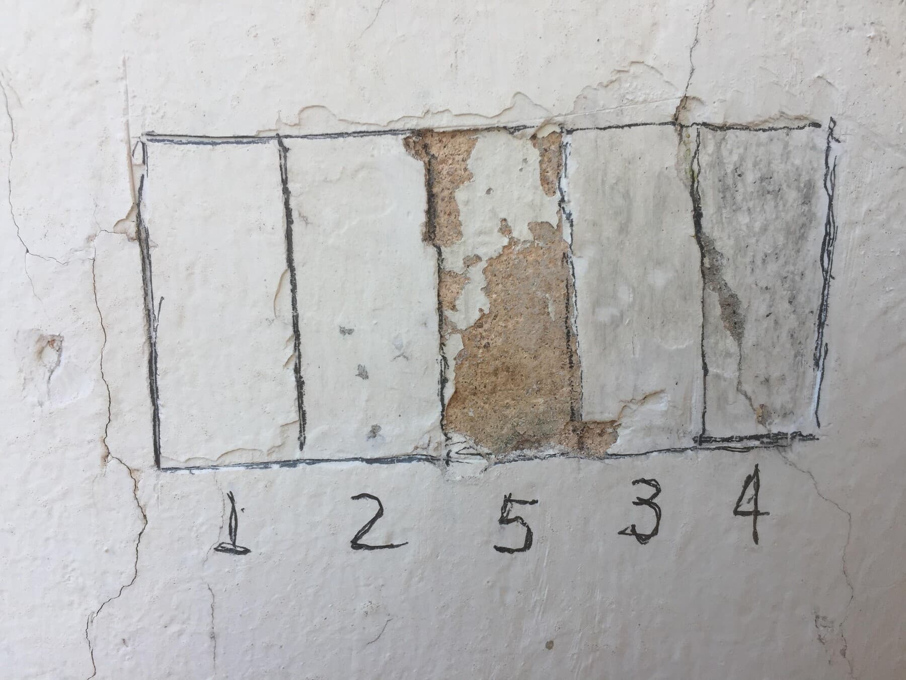 Prospecção estratigráfica: janelas abertas na parede revelam as camadas de tinta de cada época.