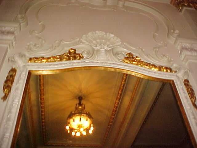 O topo da boca de cena, com a moldura em estuque e douração e o forro pintado ao fundo, restaurados.