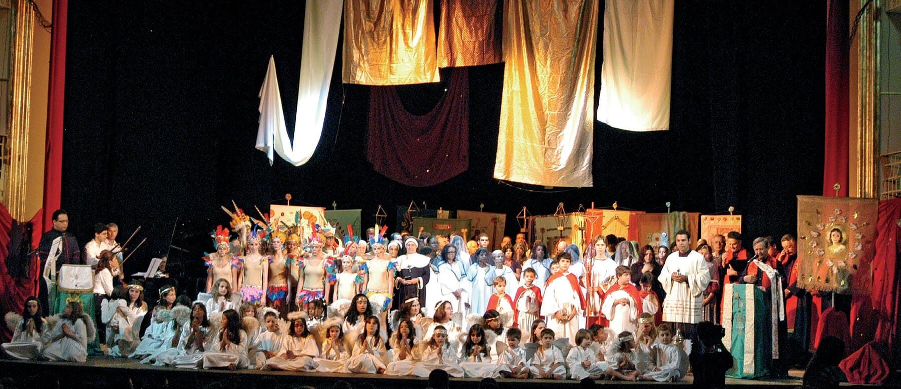 Um coral em apresentação no palco do Theatro.