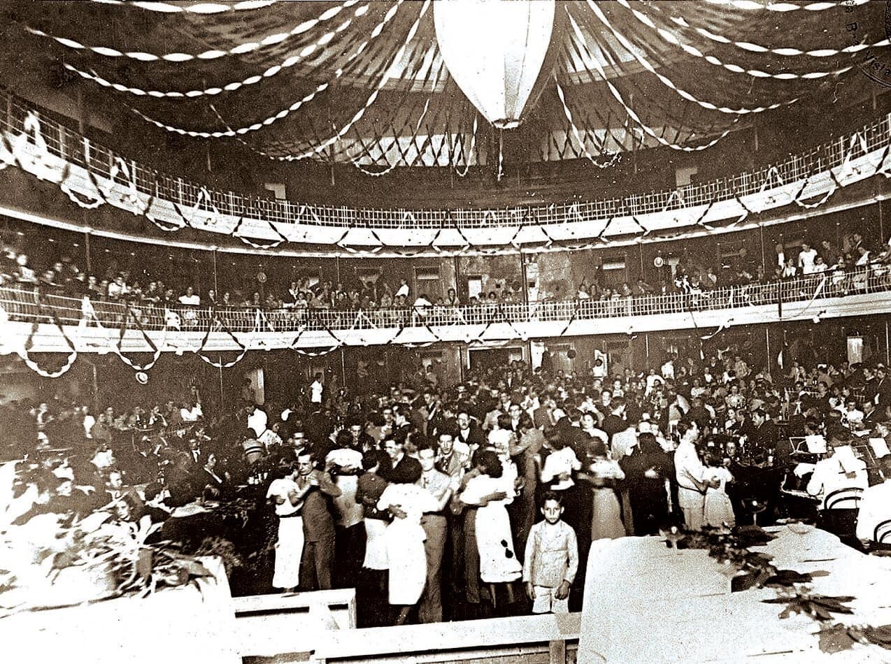Um baile na plateia do Theatro — a sala decorada e cheia, em registro de outras décadas.