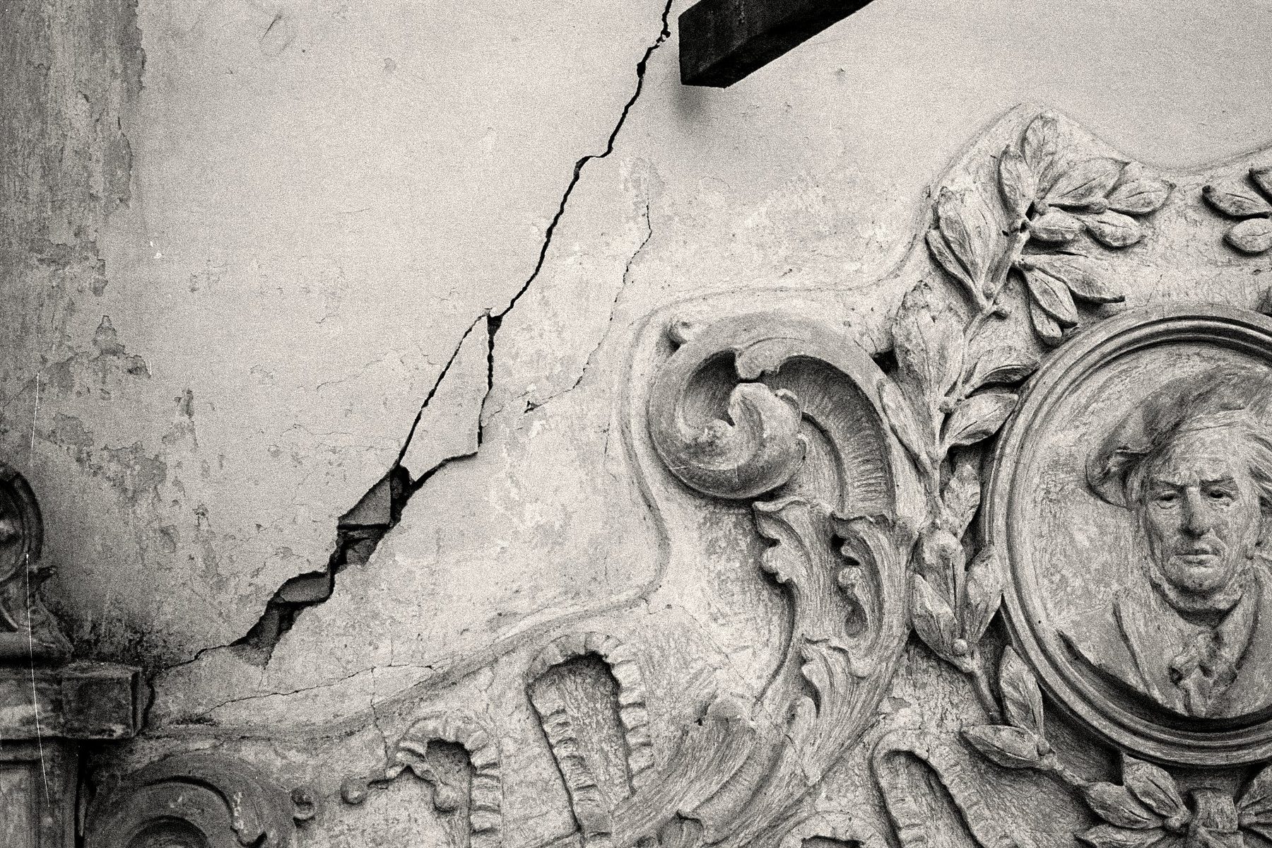 Uma rachadura aberta acima de uma porta — o estado de deterioração do edifício antes do restauro.