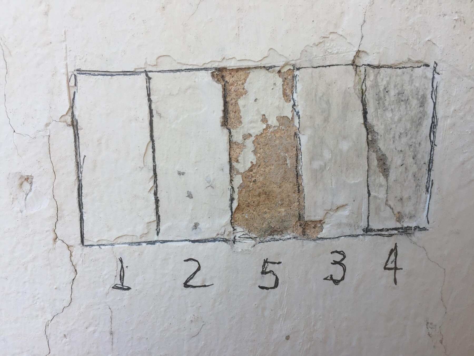 Prospecção estratigráfica: janelas abertas na parede revelam as camadas de tinta de cada época.